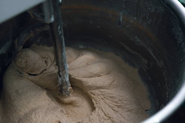 Ekmek pişirme işlemi. Hamur, un ve su katıyorum. Endüstriyel karıştırıcı, otomatik. Manzara yakın. Boşluğu kopyala