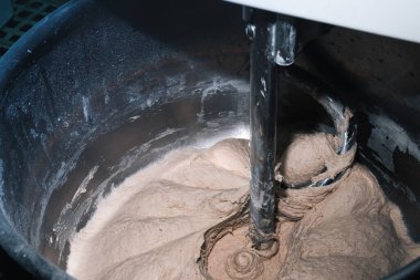 Ekmek pişirme işlemi. Hamur, un ve su katıyorum. Endüstriyel karıştırıcı, otomatik. Manzara yakın..