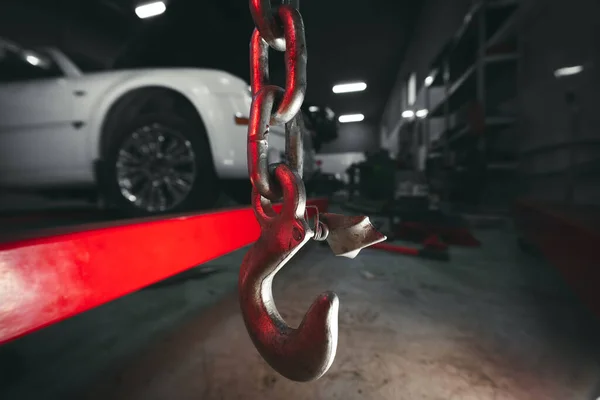 Araba servisinde motor vincini kaldırıyorum. Yakın plan. Detaylar, seçici odaklanma. Uzayı kopyala Arkaplanda bir araç