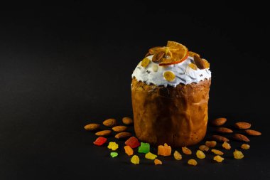 Siyah arka planda geleneksel Paskalya pastası. Göçmen, şekerli meyve, dekor. Ortodoks muamelesi. İsa Mesih 'in dirilişinin sembolü.