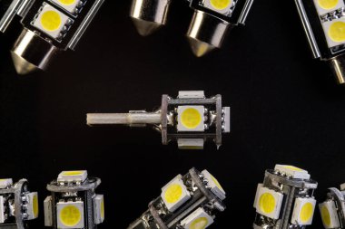 Elektronik araçlar için diyot, aksesuar ve parça yayan bir sürü araba ampulü var. kopyalama alanı. Siyah arka plan yakın plan. 12V c5w w5w T10