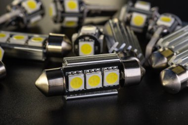 Elektronik araçlar için diyot, aksesuar ve parça yayan bir sürü araba ampulü var. kopyalama alanı. Siyah arka plan yakın plan. 12V w5w T10