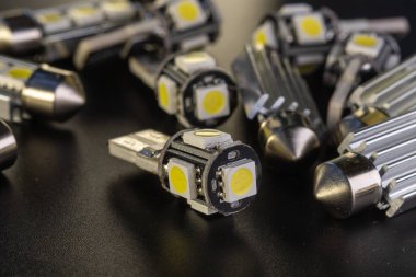 Elektronik araçlar için diyot, aksesuar ve parça yayan bir sürü araba ampulü var. kopyalama alanı. Siyah arka plan yakın plan. 12V w5w T10