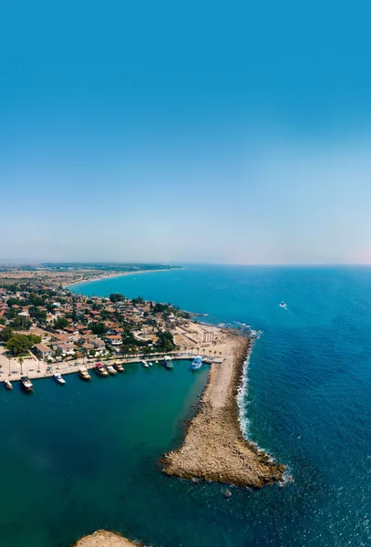 Körfezin, gemilerin ve teknelerin havadan görüntüsü. Turistik yerler, antik binalar, Kolezyum ve Apollo Tapınağı. Hindi, Manavgad, kenar. Dikey fotoğraf
