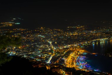 Alanya Körfezi 'ndeki Kizil Kule kulesi, Antalya' nın Antalya ilçesindeki yarımadadan görülen tekne ve gemiler. Ünlü turizm merkezi. Gece şehir manzarası.