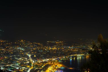 Alanya Körfezi 'ndeki Kizil Kule kulesi, Antalya' nın Antalya ilçesindeki yarımadadan görülen tekne ve gemiler. Ünlü turizm merkezi. Gece şehir manzarası.