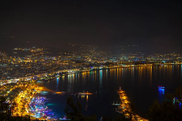 Alanya Körfezi 'ndeki Kizil Kule kulesi, Antalya' nın Antalya ilçesindeki yarımadadan görülen tekne ve gemiler. Ünlü turizm merkezi. Gece şehir manzarası.