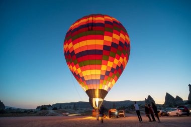Goreme, TURKEY - 27 Ağustos 2020: Balonları fırlatmak, kalkışa hazırlanmak ve turistleri gemiye almak. Kapadokya 'da sabahın erken saatlerinde gün doğumu