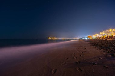 Gece kumsalı, kumsal ve deniz manzarası, şemsiyeler ve güneş panzeleri. Ay ışığı. Ceset yok. Türkiye kıyısı ve seti Alanya