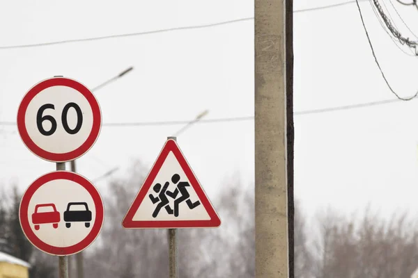 Tres señales de tráfico se mantienen juntas. una señal de adelantamiento está prohibido, la señal de restricción de velocidad. señale precaución niños — Foto de Stock