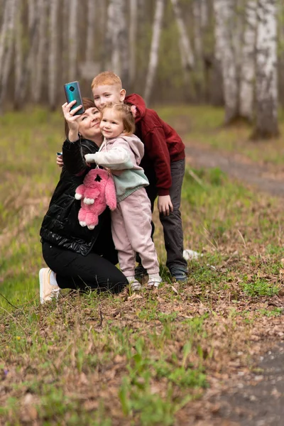 Família feliz no parque tomando selfie em um dia ensolarado — Fotografia de Stock