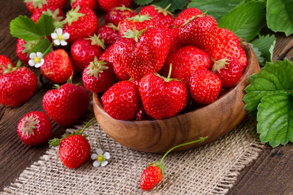 Cup met verse aardbeien op houten tafel. — Stockfoto