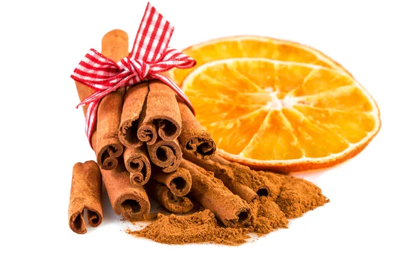 Rodajas de naranja secas con palitos de canela y canela en polvo sobre blanco . —  Fotos de Stock