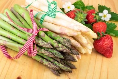 Taze kuşkonmaz ile ahşap üzerine çilek. Vegan gıda, vejetaryen ve sağlıklı pişirme kavramı.