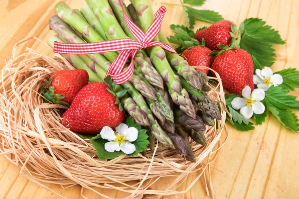Φρέσκα σπαράγγια με φράουλες στο ξύλο. Τρόφιμα vegan, χορτοφάγος και υγιεινό μαγείρεμα έννοια. — Φωτογραφία Αρχείου