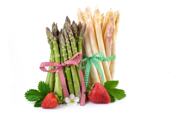 Bundel van groene en witte asperges met aardbeien. Verse gezonde groenten op witte achtergrond. — Stockfoto