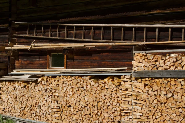 Firewood stacked by the alpine hut. Rustic farming scene. — Stock Photo, Image