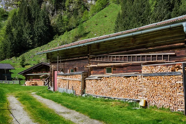 Rustic farming scene. Firewood stacked by the alpine hut. — Stock Photo, Image