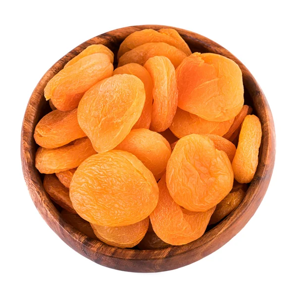 Dried apricots in wooden bowl on white background. Top view. — Stock Photo, Image