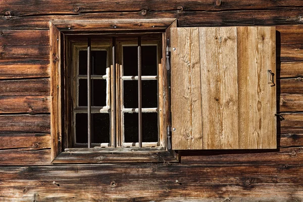 Venster van een houten alpenhut. Rustieke achtergrond — Stockfoto