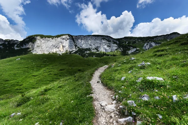 Low angle view of mountain range with hiking path under cloudy sky. Achensee Area, Tyrol, Austria. — Stock Photo, Image