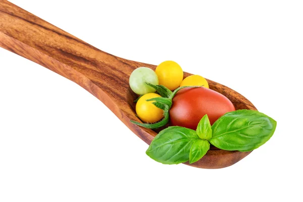 Pomodori su cucchiaio di legno con concetto di cottura delle foglie di basilico — Foto Stock