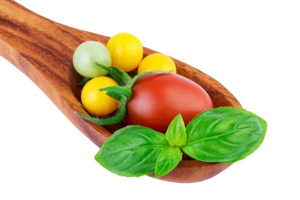 Pomodori su cucchiaio di legno con basilico foglia verdura fresca concetto di cottura — Foto Stock
