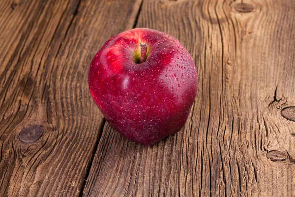 Червоне яблуко на дерев'яному фоні — стокове фото