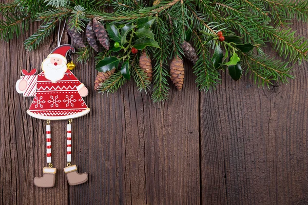 Weihnachtsmann mit Tannenzweig über Holzhintergrund — Stockfoto