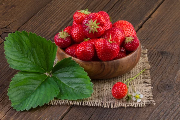 Reife Erdbeeren in Schale auf Holzgrund — Stockfoto