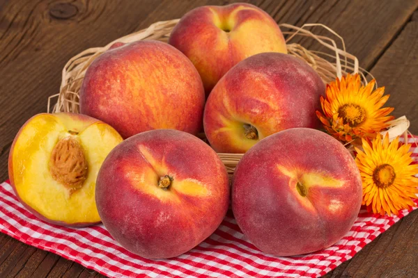 Peaches on red checkered tablecloth — 图库照片