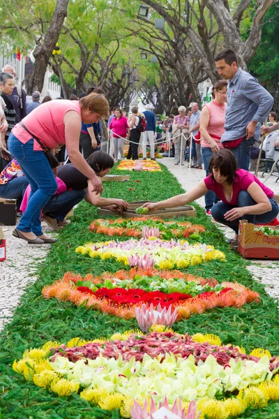 FUNCHAL, MADEIRA - 16 DE ABRIL DE 2015: En el centro de Funchal, a lo largo del paseo central de la Avenida Arriaga, se crean las famosas alfombras florales . — Foto de Stock