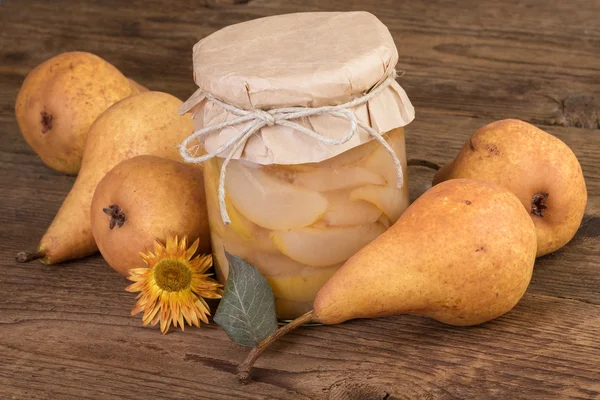 Jar with pears compote and ripe fruits — Stock Photo, Image