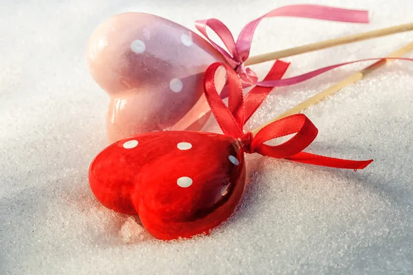 Valentines Day, two red hearts on ice wet snow, selective focus — Stock Photo, Image