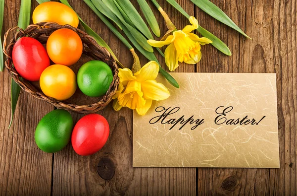 Ostern Hintergrund mit Frühlingsblumen und Papier Blatt Text frohe Ostern — Stockfoto