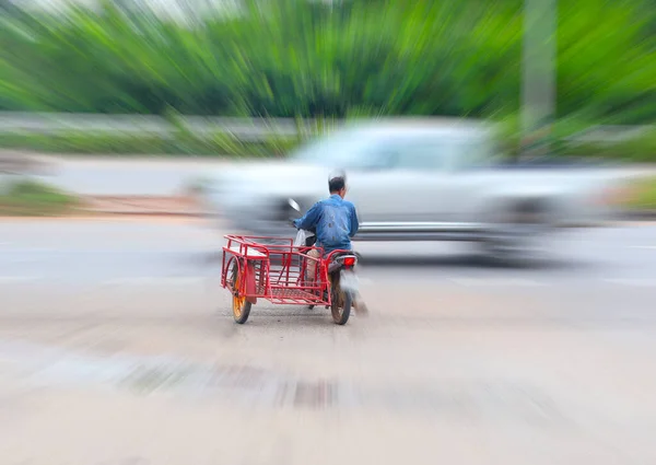 Picture of a motorcycle driver with a sidecar for transporting goods on the road