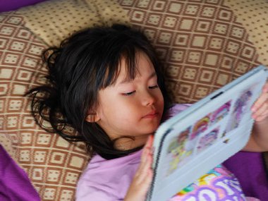 A girl staring at her iPad blurs some images.