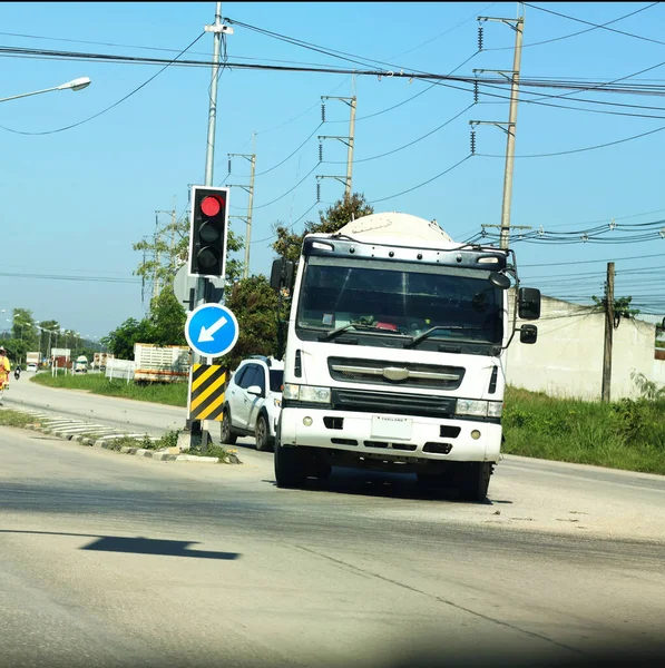 Büyük beyaz bir beton karıştırıcı kamyon yolda gidiyor..