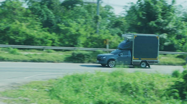 Kamyona dönüşmüş bir kamyonet biraz bulanık bir yolda ilerliyor..