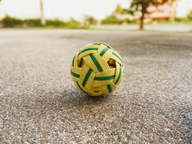 Sarı ve yeşil yapay rattan sepak takham toplar açık hava cilalı taş zemin üzerine yerleştirilir..