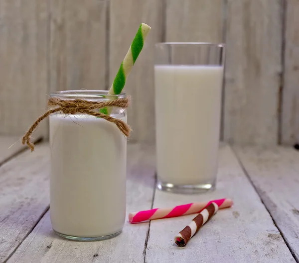 Bottle of milk with wafer stick on the wooden background — Stock Photo, Image