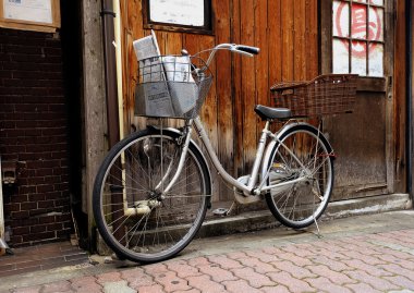 Bisiklet taşımak karşı ahşap arka plan eğilerek gazete