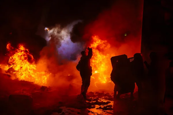 Manifestantes em chamas com câmera e escudos — Fotografia de Stock