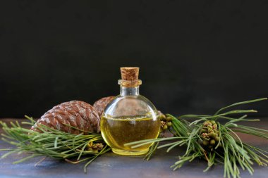 Ahşap masada bir şişe çam yağı.