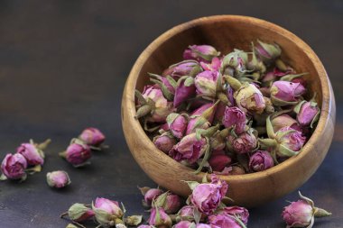 Tahta masada kasede küçük tomurcuk gülleri