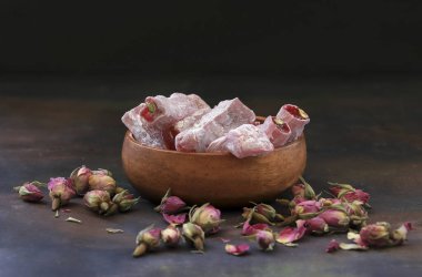 Türk gülü ve küçük gül tomurcukları masada, ahşap kasede..