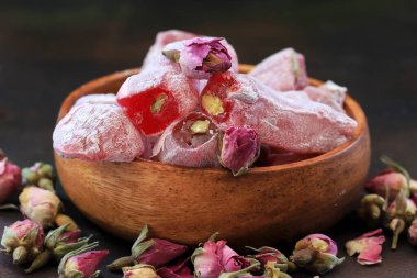 Türk gülü ve küçük gül tomurcukları masada, ahşap kasede..