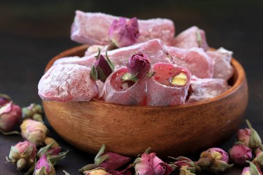 Türk gülü ve küçük gül tomurcukları masada, ahşap kasede..