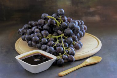 Grape molasses and fresh organic grapes clipart