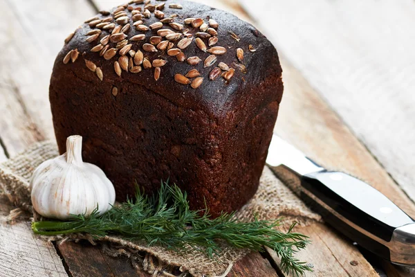 Bochenek chleba, nóż i warzywa — Zdjęcie stockowe